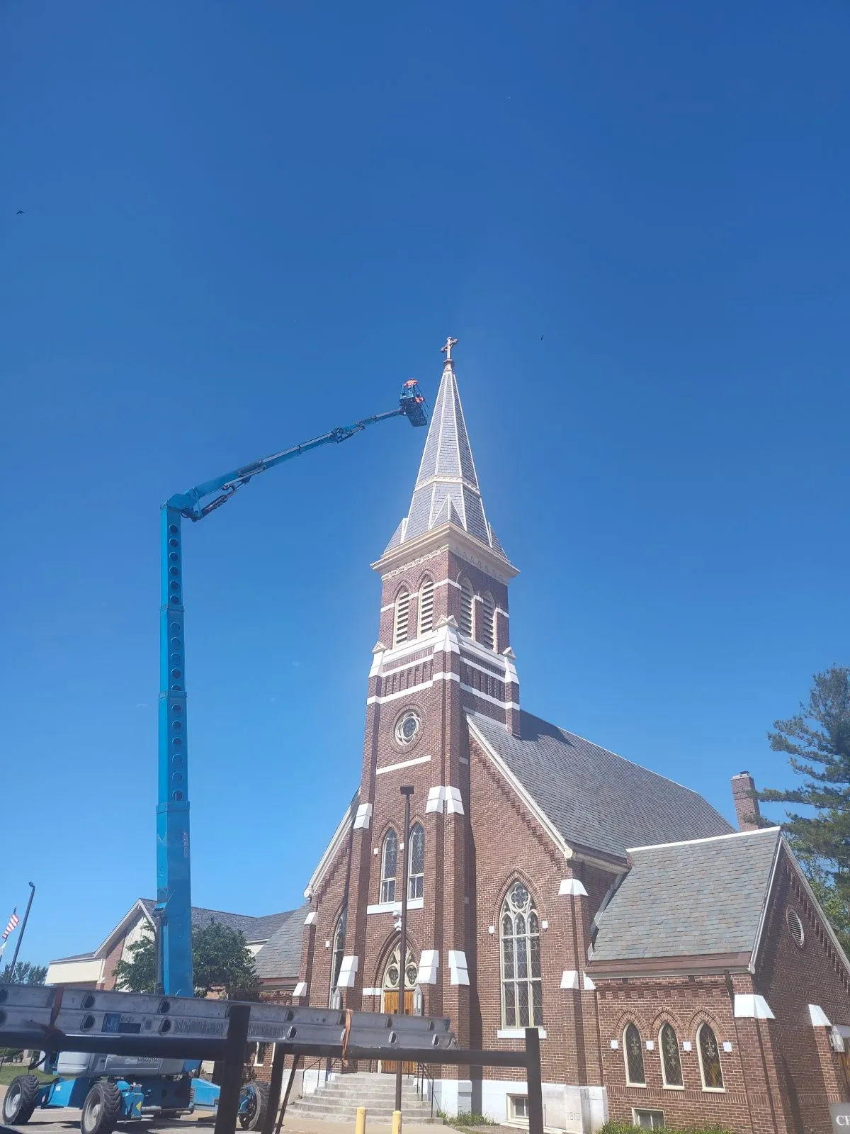 DG Builders roofing a church steeple with boom lift in Genesee County Michigan